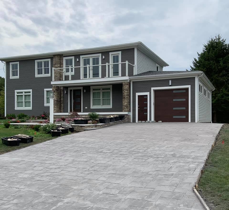 Newly built home with stamped concrete driveway and stone accents in Fall River MA